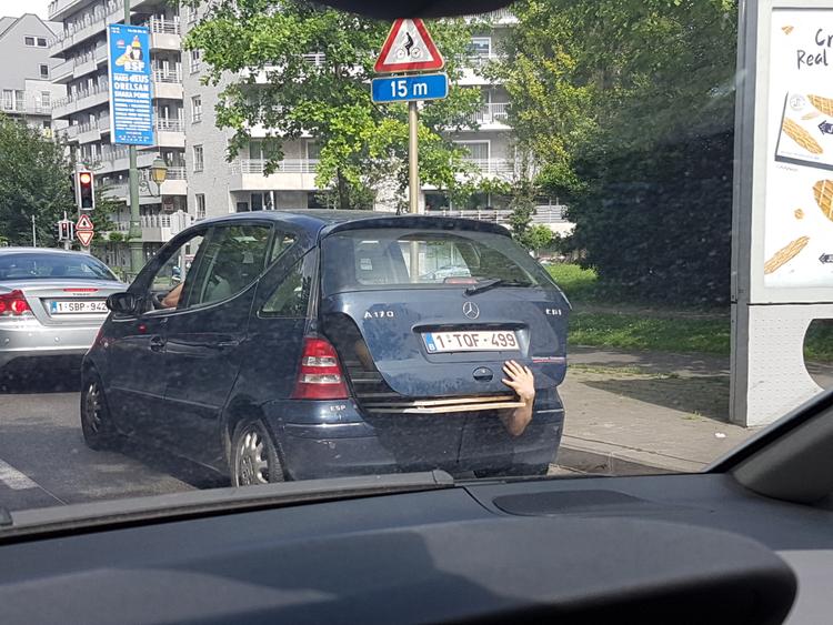 Car passenger holding the trunk shut during drive